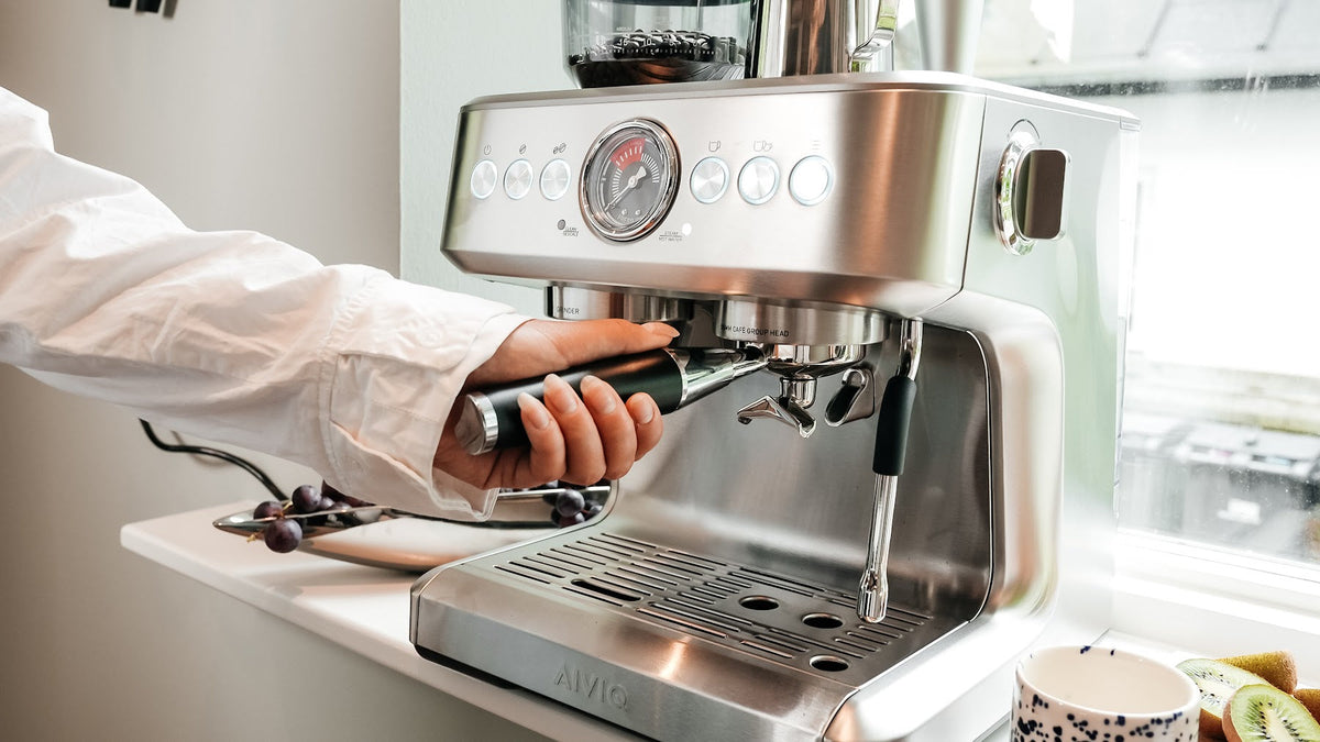 En hand sätter portafiltret i en Aspire Brew i morgonljus