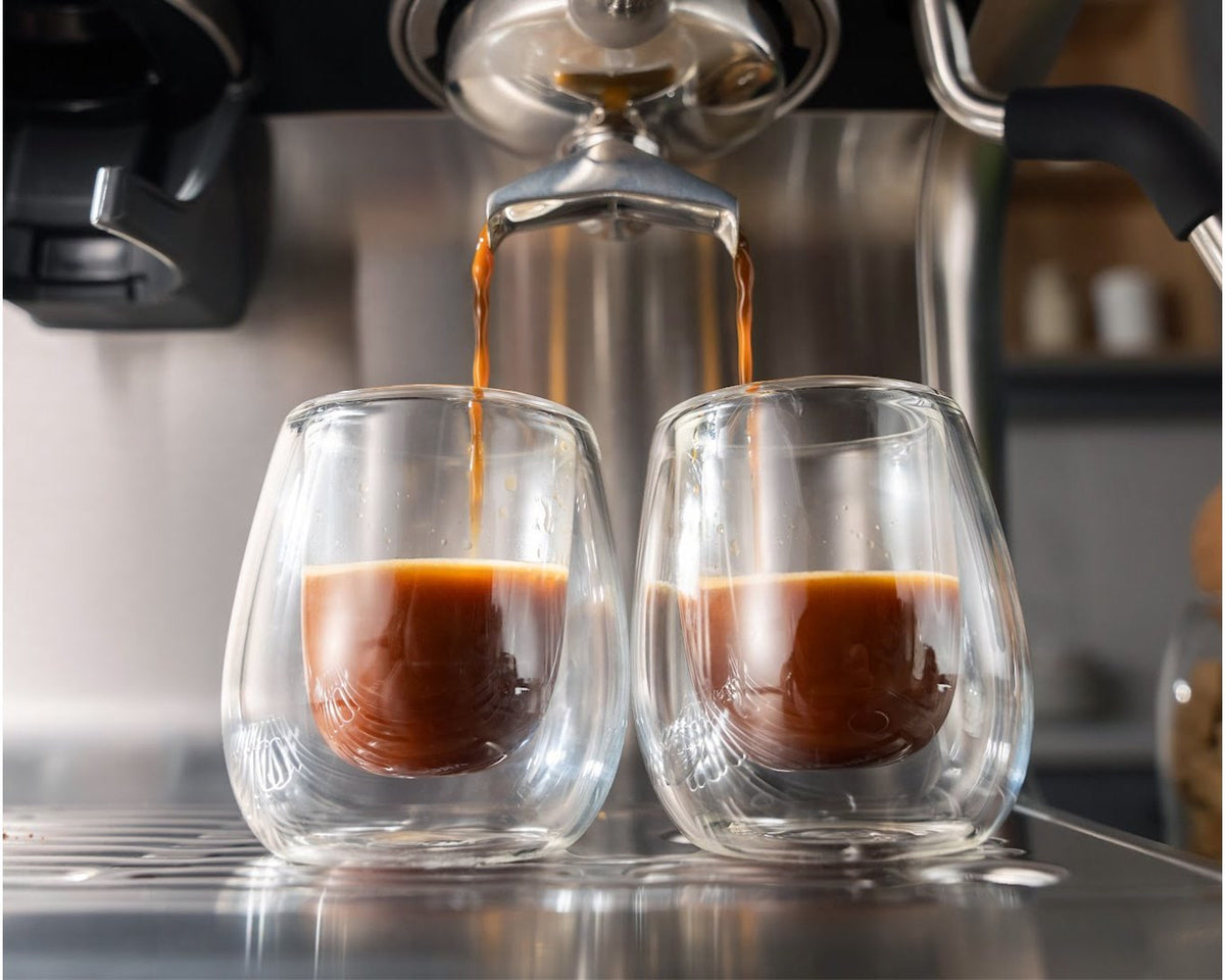 Espresso rinner från portafiltrets två utlopp ner i två dubbelväggiga glas