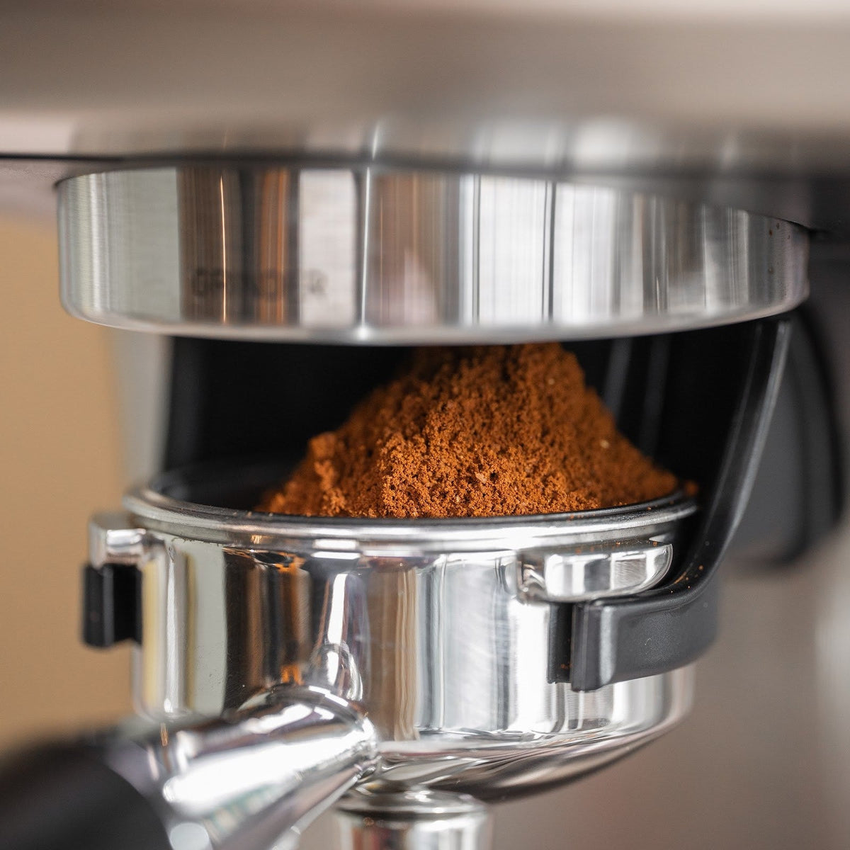 Nymalet kaffe i en topp i portafiltret, som står i kvarnhållaren under kvarnen på Aspire Expert. Vågen sitter i kvarnhållaren.